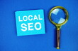 © may1985 - Local SEO text on sticky note with magnifying glass on blue background