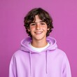 © SunPunjiStudio - Happy teenage boy smiling in a purple hoodie against a vibrant background