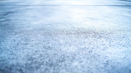 Poster - Close-up view of a raw concrete surface featuring a rough texture illuminated by angled light, emphasizing its modern, industrial look ideal for design projects