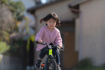 Wall Mural - 自転車練習を頑張る幼い女の子