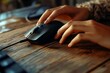 © ceoJAHID - Closeup of a female hand using a computer mouse on a wooden table
