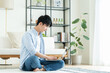 © pain au chocolat - リビングでパソコンを使う若い男性