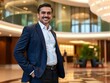 © Chalermrach - Middle eastern businessman in formal attire looking confidently at the camera, standing in a luxurious hotel lobby with copy space, standing, business