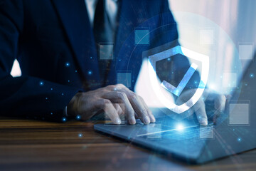 Wall Mural - Man working on a laptop with advanced cyber security shield, ensuring the protection of sensitive data and securing the digital environment against potential threats.