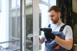 © Serhii - Worker installing plastic window indoors.