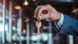 © Yuparet - Close-Up View of a Hand Holding a Key in a Modern Setting with Soft Lighting