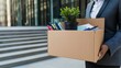 © utaem2022 - Businesswoman carrying cardboard box with belongings after job loss