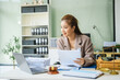 © NanSan - A young female lawyer sits at her desk in the office, providing online legal advice professionally. Legal documents, a computer, a judge's gavel, and scales symbolize justice and law
