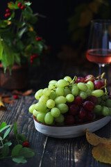 Wall Mural - A bowl with red and green grape in rustic style	