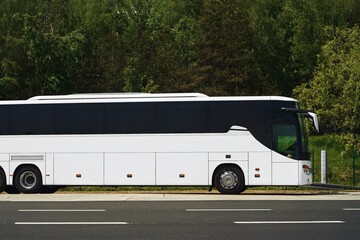 white tour bus parked on empty road