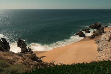 Poster - Serene coastal view with sandy beach and rocks