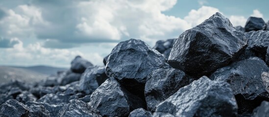 Poster - Black Rocks Against Light Clouds and Sky with Empty Space for Text in Background Natural Scenery and Textured Surface