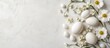 © The 2R Artificiality - Joyful Easter flat lay featuring white flowers and eggs on a light backdrop with ample space for text and celebration themes.