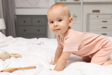 Wall Mural - Cute little baby with rattles on bed indoors, space for text