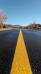 Wall Mural - Yellow line on wet road stretching into cloudy horizon on a rainy day