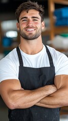 Wall Mural - A man in an apron with his arms crossed smiling at the camera