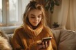 © Yuliia - close-up shot of a young woman sending a text message on her mobile phone in the comfort of her home. The focus is on the phone screen as she types out a message