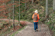 © EdNurg - Senior woman hiking alone in the forest enjoying trekking on a gravel path