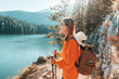 © EdNurg - Female hiker with backpack and trekking poles enjoying the sunny autumn day in Durmitor National Park, Montenegro