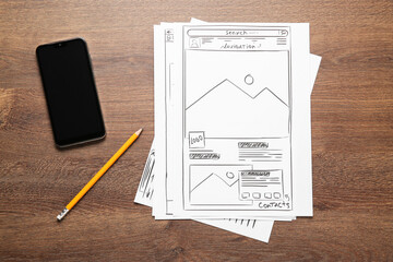 Wall Mural - developing ui design. sketches of website wireframes, pencil and smartphone on wooden table, top vie