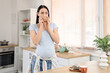 © Pixel-Shot - Young pregnant woman drinking tea in kitchen