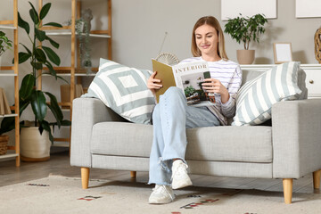 Wall Mural - Young woman reading magazine on sofa at home