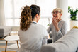 © Dorde - Caucasian female physician in white coat conducts friendly medical consultation with senior patient during residential healthcare visit, sharing positive interaction.