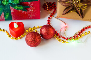 Red, shiny Christmas balls with chains in front of gift packages