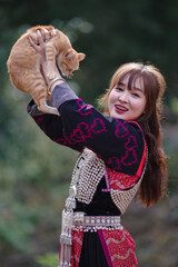 Girl of Lisu Hill Tribe holding and red raising cat.