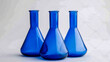 © tahamina - Three blue beakers and test tubes on a light background