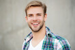 © be free - Casual style of millennial man. Portrait of man in casual style shirt. Stylish face portrait of unshaven guy. Handsome young man outdoor. Millennial man smiling and wearing checkered shirt