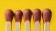 © Rasim - Macro shot of four matches aligned in a row against a striking yellow backdrop, highlighting the details and textures of the matches in this captivating composition.