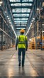 © Wanida - Professional engineer in reflective vest and helmet walking through an industrial warehouse, observing heavy equipment and ensuring safety measures align with operational standards