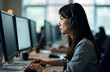 © Irentravel - A woman is sitting in front of a computer while wearing a headset.