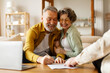 © Home-stock - Happy senior couple signing real estate lease contract indoors, elderly man and woman filling paper form, meeting with realtor