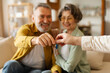 © Home-stock - Realtor giving senior couple key to new house, happy older real estate owners making purchase deal. Family bought or rented apartment, focus on hands