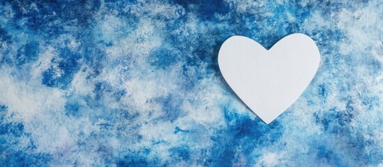 Wall Mural - Valentine's Day heart shaped white paper on textured blue backdrop with space for romantic text or messages flat lay composition