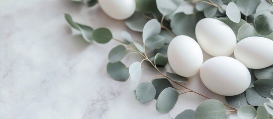 Aufkleber - White Easter eggs arranged with fresh eucalyptus leaves on a marble surface for a spring-themed decoration or celebration aesthetic
