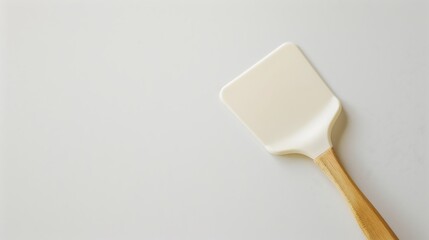 A silicone spatula resting on a clean white backdrop