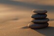 Close-up of smooth stones stacked on sandy beach.
