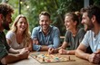 © Pete - Happy friends play board game together indoors. Sitting around table, enjoying time. Fun leisure activity for group of friends. Group of young adults pleasant conversation. Joyful moment at home.