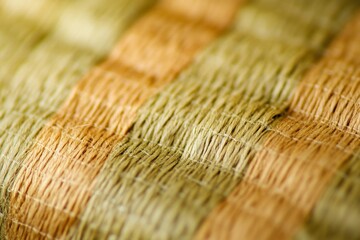 Fototapete - A detailed close-up of a woven texture in earthy hues, showcasing the intricate interlacing pattern of the fibers, revealing natural color variations.