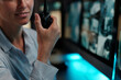 © pressmaster - Hand of young female security officer holding transceiver and reporting about accident while sitting in surveillance room of hotel