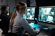 © pressmaster - Young serious woman with long blond hair sitting by workplace with desktop computer and observing cctv video camera