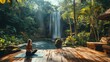 © afif - Woman meditating by jungle waterfall.