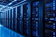 © Downloads - Rows of powerful server racks in a modern data center facility with glowing blue lights