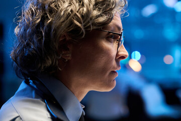 Aufkleber - Profile of grey haired mature female officer in eyeglasses looking at computer screen with data in front of camera