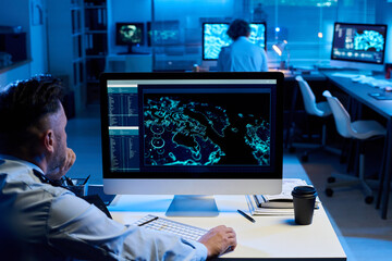 Aufkleber - Pensive mature man clicking mouse and looking at screen of desktop computer with graphic data while sitting by workplace