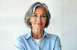 © miss irine - Confident mature woman stands against white background. Senior businesswoman with gray hair looks directly at camera with pleasant expression. Pro, successful female executive business leader.