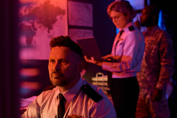 Aufkleber - Mature male worker of military command center looking at computer screen while analyzing online data against coworkers